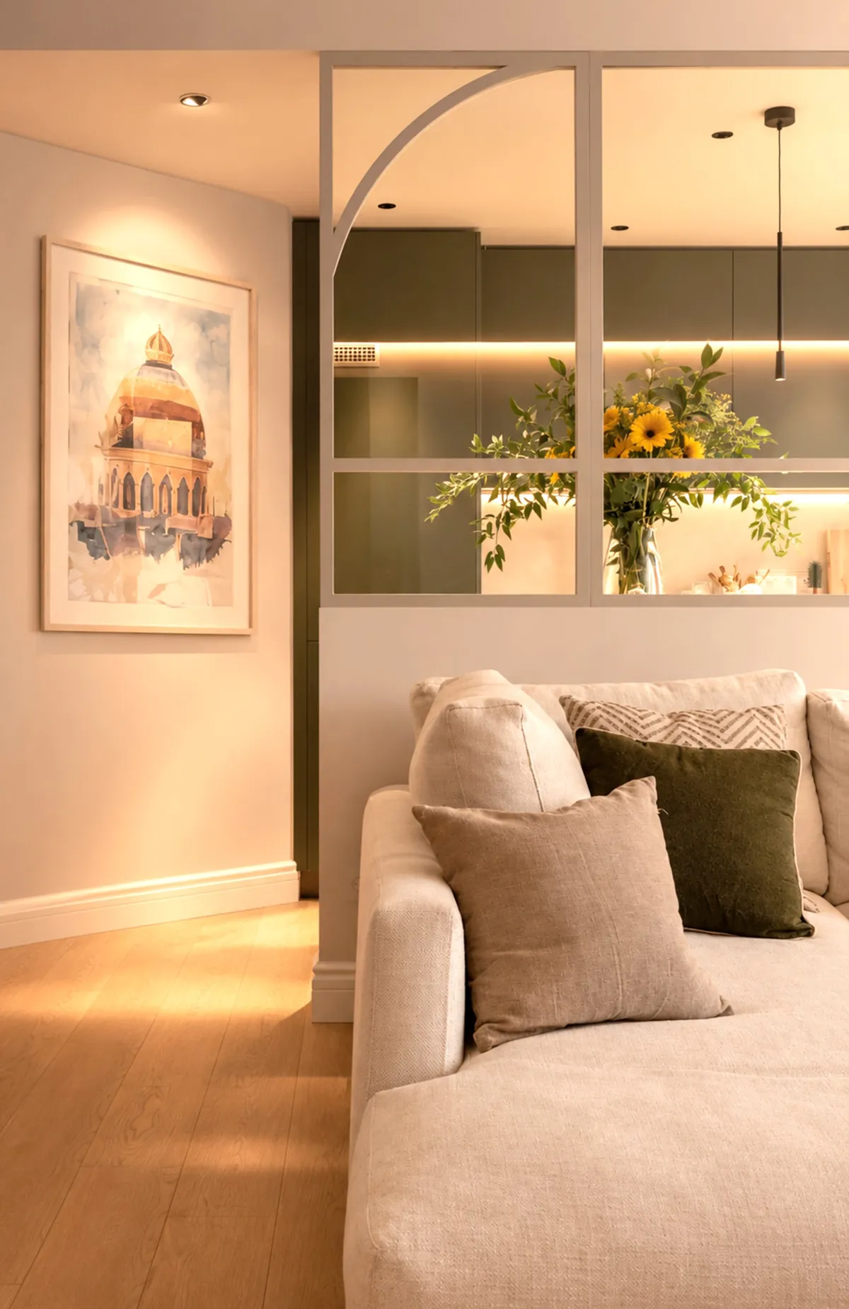 Salón con sofá de lino y vidriera con arco que conecta con la cocina