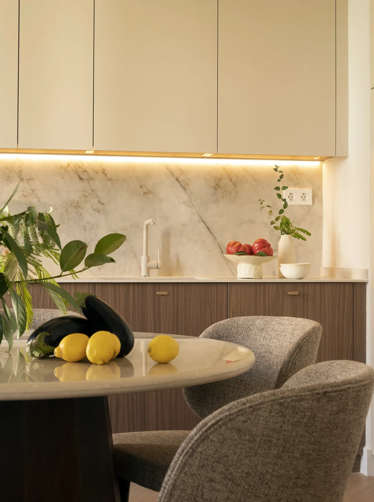 Walnut kitchen fronts and a backlit stone splashback