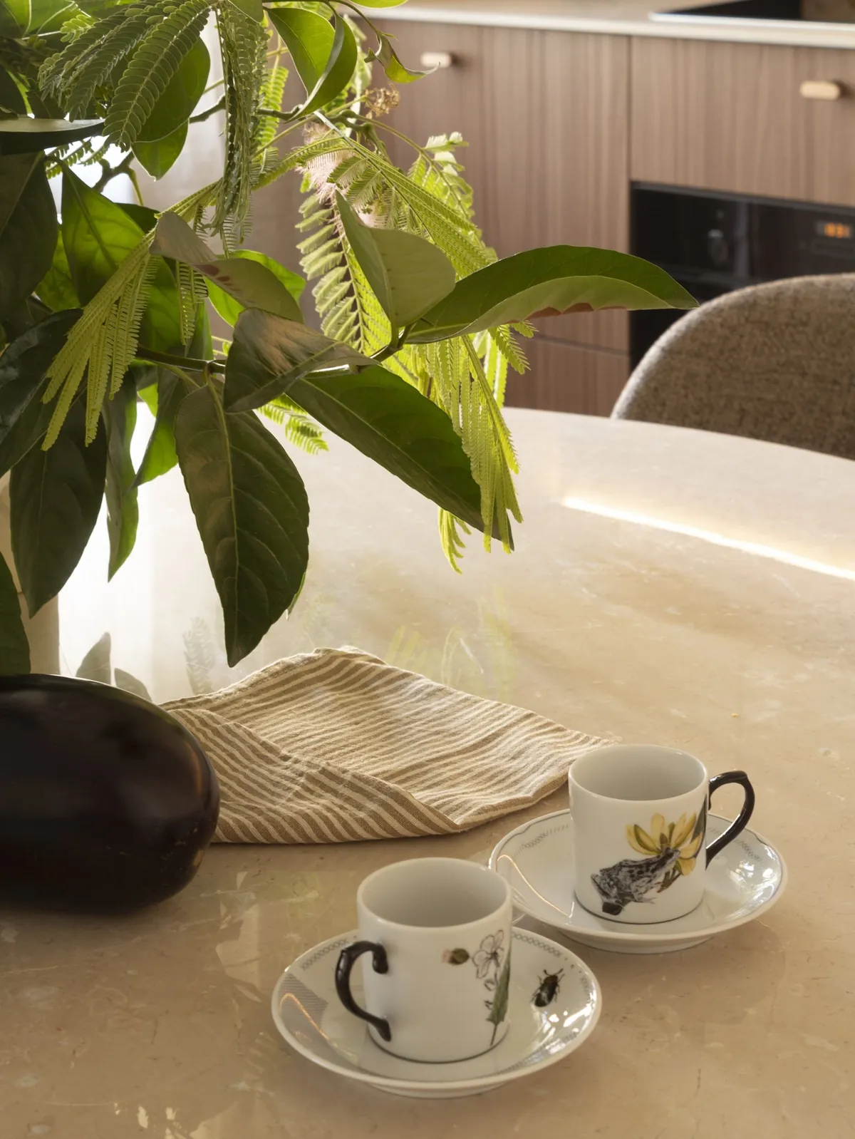 Detail of the stone dining table with porcelain cups and green branches
